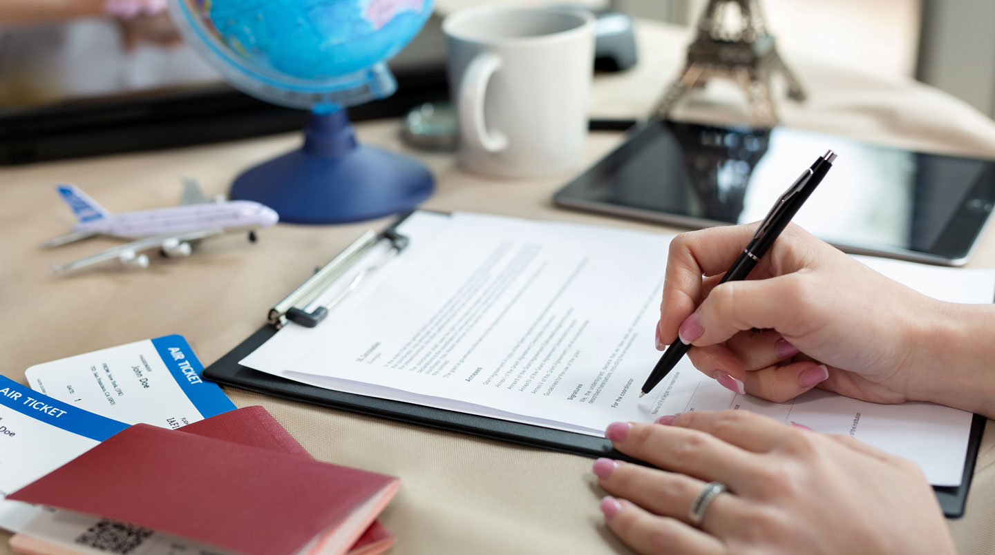 Conseillère d'agence immobilière vendéenne montrant les disponibilités de locations de vacances sur écran à un couple de clients dans un bureau contemporain